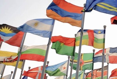 Flags from around the world on poles, blowing in the wind