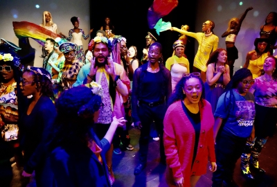NYU students, large group in colorful costumes on stage