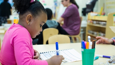 Young girl writes at a desk