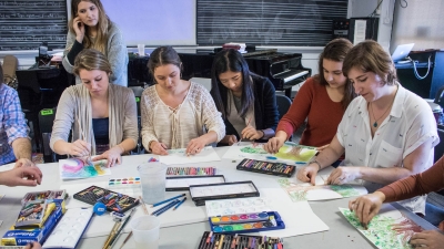 Students working on art projects around table