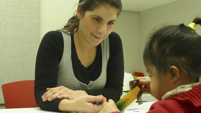 NYU Student working with a young child