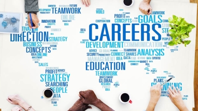 professionals collaborating at table covered with a world map made of business and education keywords 