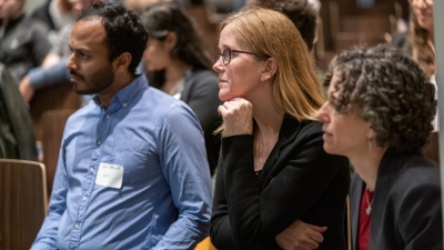 Three people listening to a presentation