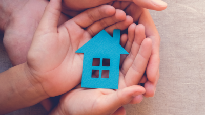 picture of hands and a paper doll house