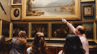 Professor pointing at painting. 