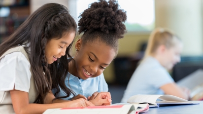 Two children reading a book together