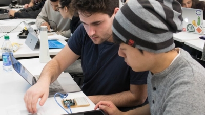 Two male students examine computer circuits 
