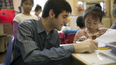 male teacher instructing young student