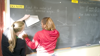 teacher and student working together on the chalkboard