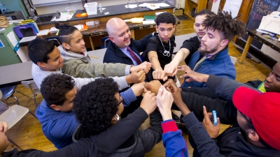 young students in a group huddle
