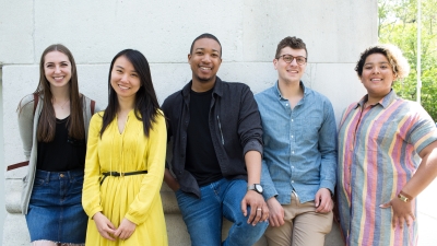 Five Steinhardt students leaning against the Washington Square Arch