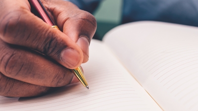 Photo of someone writing with pen