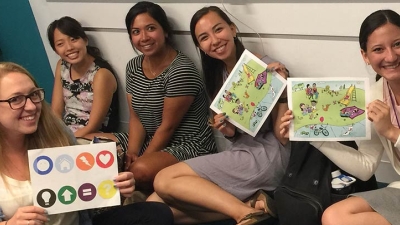 Students holding up sheets of paper used to conduct activities and research in the lab.