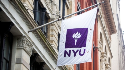 The NYU flag flying from the side of a building
