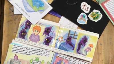 Drawings and student made books on table.