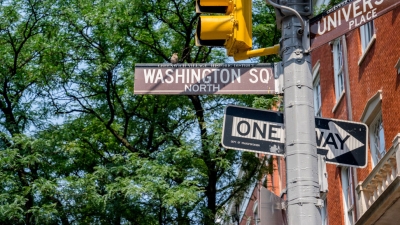 Washington Square street signs and stop lights against a backdrop of green trees