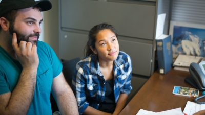 Two graduate students speaking with an advisor