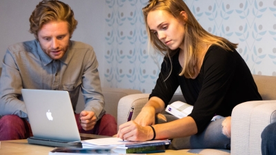 Two graduate students working with a laptop