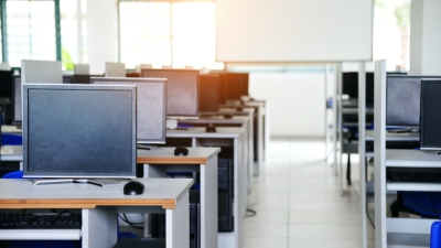 A brightly lit computer lab with rows of monitors
