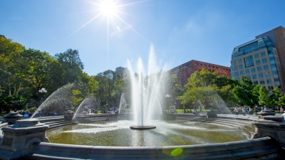 The Washington Square fountain on a bright sunny day looking east