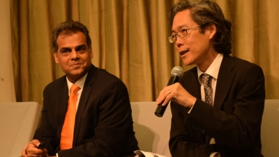 Drs. Ajay Chaudry and Hiro Yoshikawa sitting together with Dr. Yoshikawa speaking into a microphone