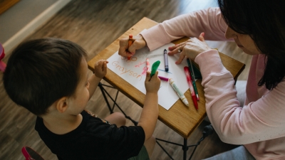 Teacher helping a child color