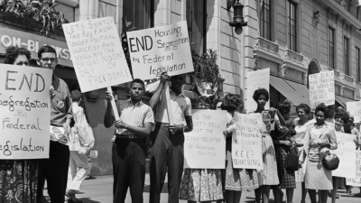 A group of mostly black protestors hold up protest signs demanding civil rights