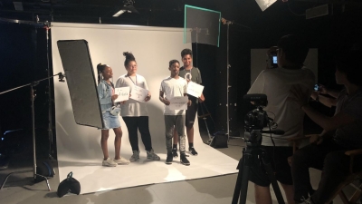 A behind-the-scenes photo of four students from the College & Career Lab in a photoshoot