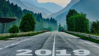 A road with 2019 written on it leads into a mountain landscape