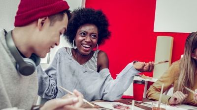 3 art students at a table painting