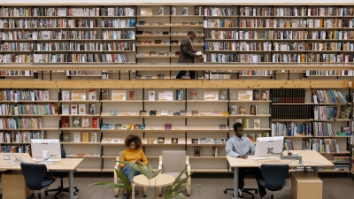  Teacher walking across balcony, students working in library below