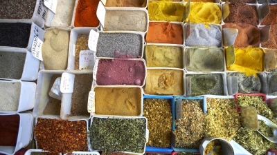 A photo from above of many containers of multicolored spices