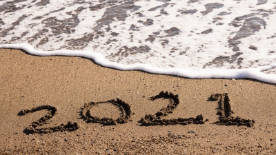 2021 written in sand near water.