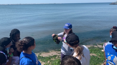 NYU educator showing 5th graders a horseshoe crab at Plumb Beach