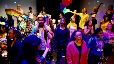 NYU students, large group in colorful costumes on stage