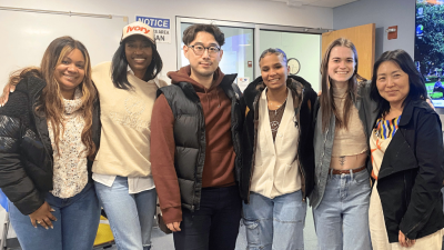 6 people standing in a classroom