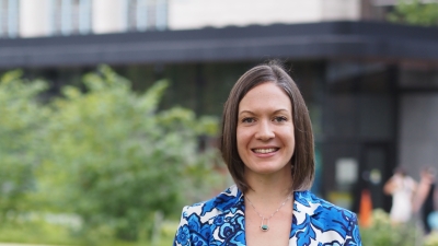 Professional headshot of Amanda Blewitt; smiling and wearing a blue, floral patterned blazer