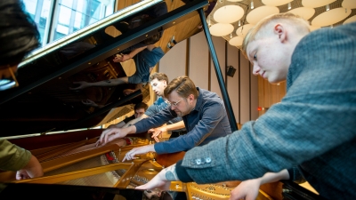 five students examining inside of a grand piano