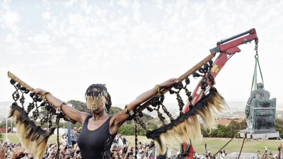 A masked woman with hands outstretched 