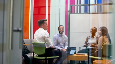 Professor Ravi Shroff sitting and conversing with 3 students