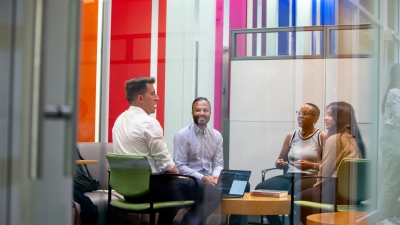 Professor Ravi Shroff sitting and conversing with 3 students