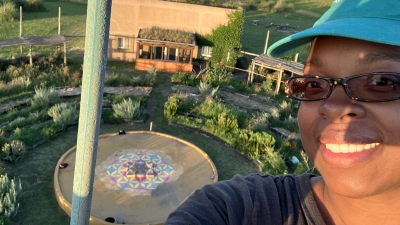 Selfie of Jillian with the "Flower of Life" in the background, the organization icon for Quinta Esencia, School of Sustainability 