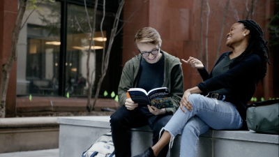 IE Doctoral Students laughing together on a park bench