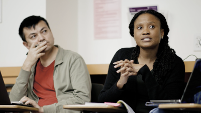 Candid photo of 2 International Ed doctoral students sitting in class