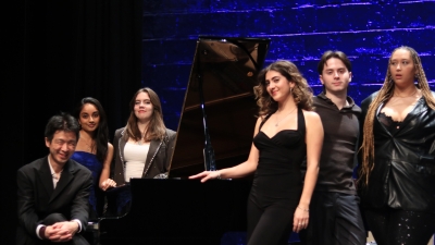 students and pianist posing at piano