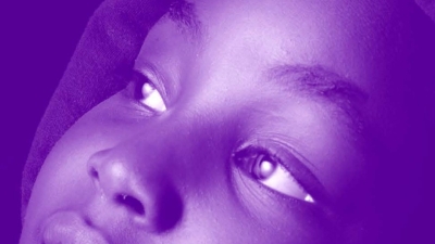 Image captures an Black child wearing a hooded sweatshirt looking off in the distance. The photo has a purple colored gaze over the entire image.