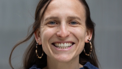 headshot of woman smiling with hoop earrings
