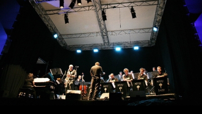 Low view shooting upward to the stage where band is playing under bright lights