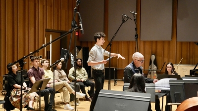Composition student explaining piece of music to orchestra