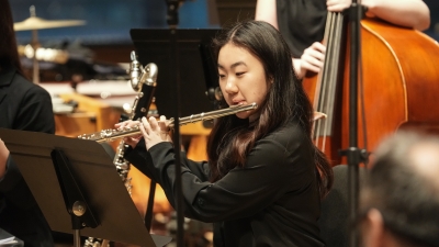 Student playing flute in orchestra
